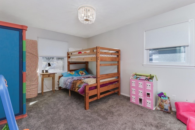 bedroom featuring a chandelier and dark carpet