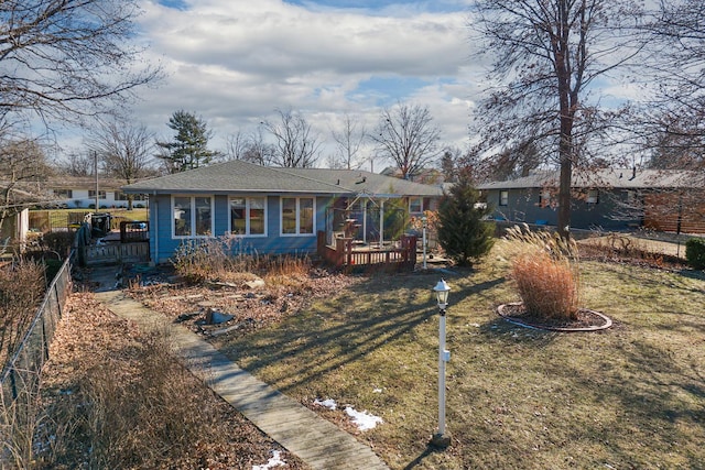 single story home featuring a wooden deck and a front lawn