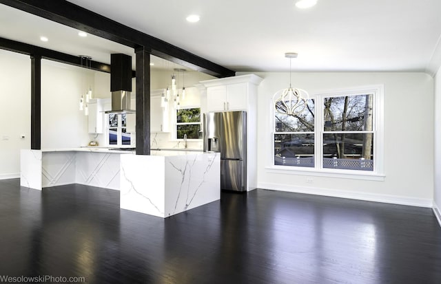 kitchen with lofted ceiling with beams, white cabinets, hanging light fixtures, light stone counters, and stainless steel fridge with ice dispenser