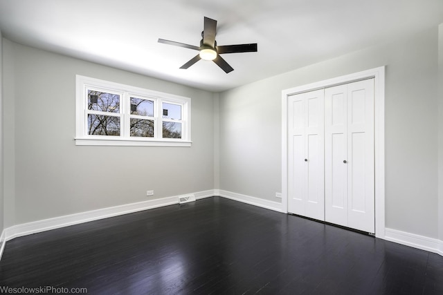 unfurnished bedroom with dark hardwood / wood-style floors, ceiling fan, and a closet