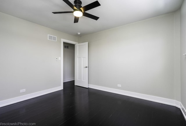 spare room featuring dark wood-type flooring and ceiling fan