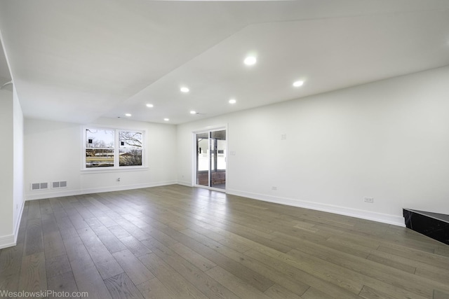 unfurnished living room featuring lofted ceiling and dark hardwood / wood-style flooring