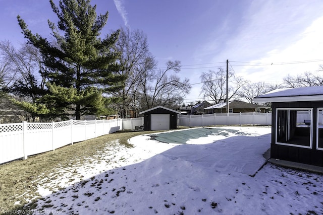 yard layered in snow with an outbuilding and a garage