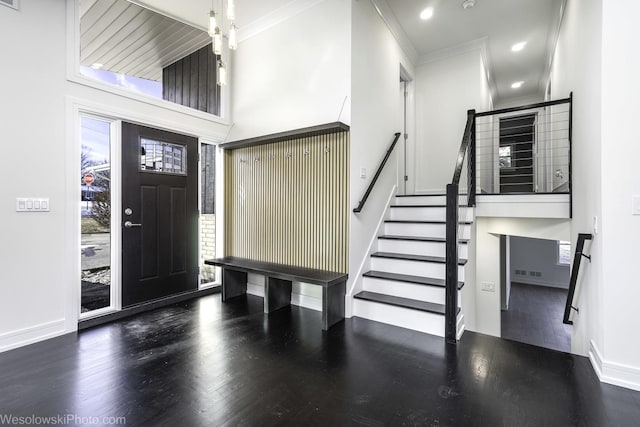 entrance foyer featuring ornamental molding, a healthy amount of sunlight, and dark hardwood / wood-style flooring