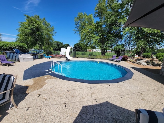 view of pool featuring a patio area, a hot tub, and a water slide