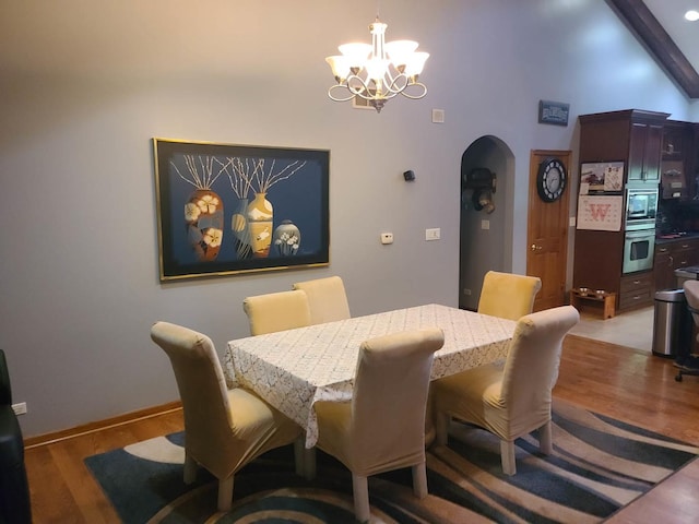 dining area featuring beamed ceiling, hardwood / wood-style floors, and a notable chandelier