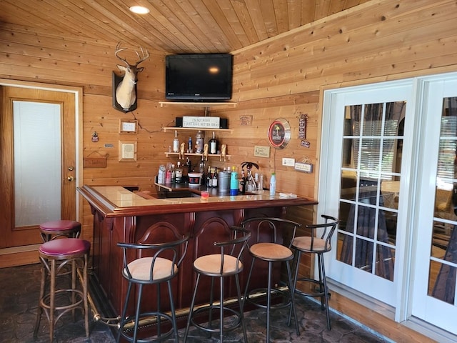 bar featuring wood ceiling and wood walls