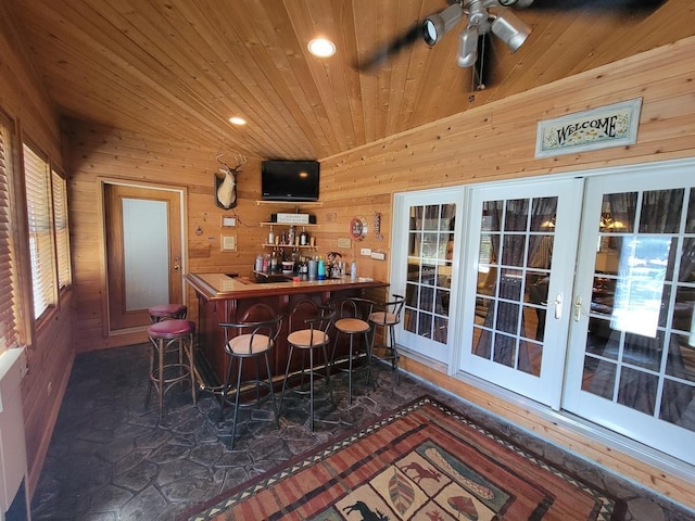 bar featuring wood counters, wood walls, ceiling fan, wooden ceiling, and french doors