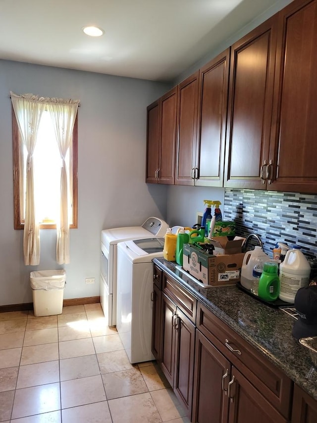 clothes washing area featuring light tile patterned flooring, cabinets, and washer and dryer