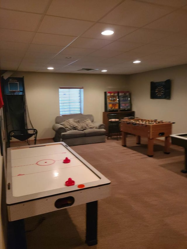 recreation room with a paneled ceiling and carpet floors