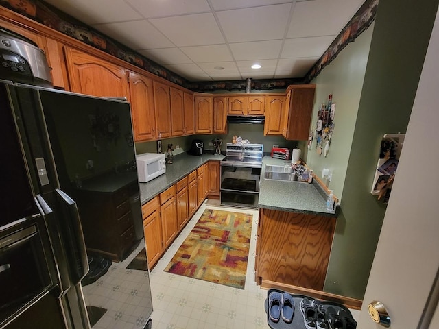 kitchen featuring a paneled ceiling, sink, fridge with ice dispenser, and electric range