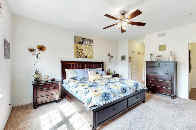 bedroom with light carpet, ceiling fan, and a closet