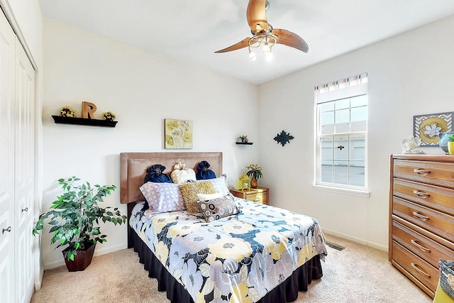 carpeted bedroom featuring ceiling fan and a closet