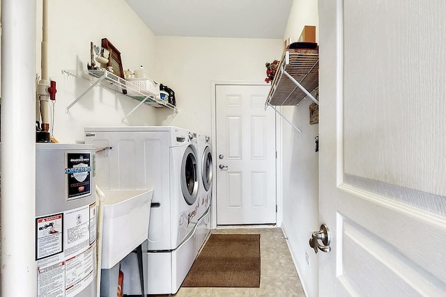 washroom with gas water heater and washer and dryer