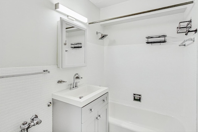 bathroom with tile walls, vanity, and bathing tub / shower combination