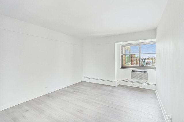 unfurnished room featuring a wall mounted AC and light hardwood / wood-style floors