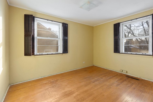 unfurnished room featuring ornamental molding and light hardwood / wood-style floors