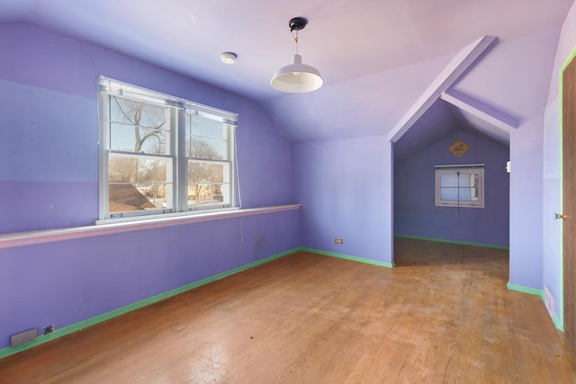 additional living space featuring vaulted ceiling and light hardwood / wood-style flooring