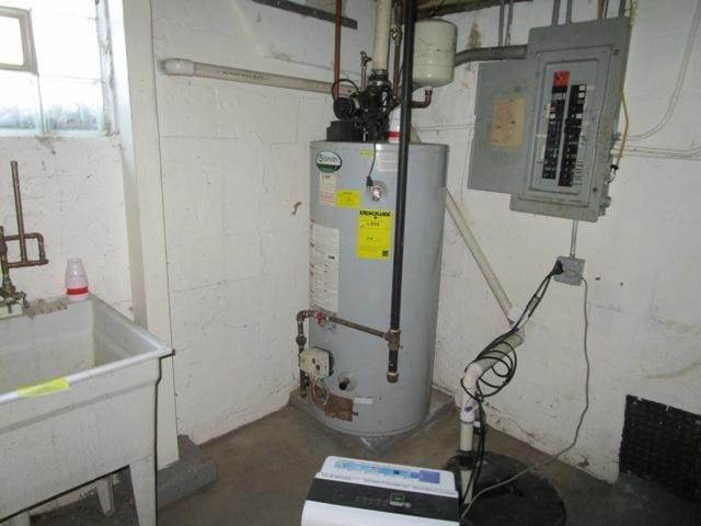 utilities featuring gas water heater, sink, and electric panel