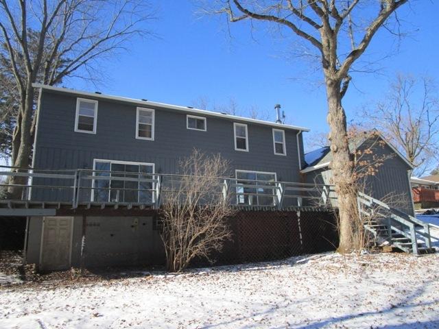 snow covered rear of property featuring a deck