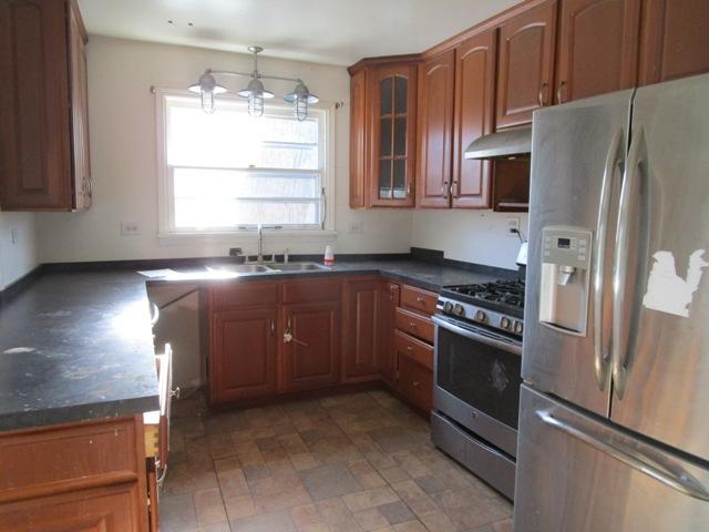 kitchen with appliances with stainless steel finishes, decorative light fixtures, and sink