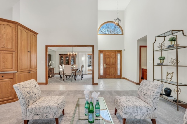 tiled foyer entrance with a notable chandelier and a towering ceiling