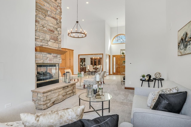 carpeted living room featuring a stone fireplace, a towering ceiling, and an inviting chandelier