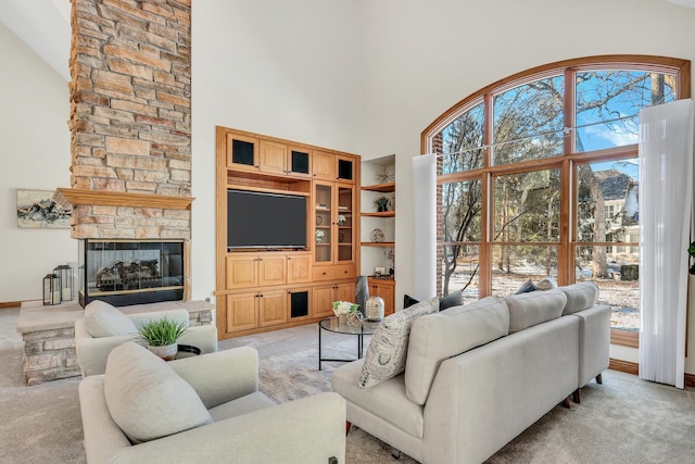 carpeted living room featuring a high ceiling, a fireplace, and built in shelves