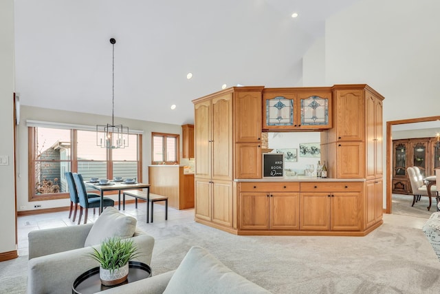 carpeted living room featuring an inviting chandelier and high vaulted ceiling