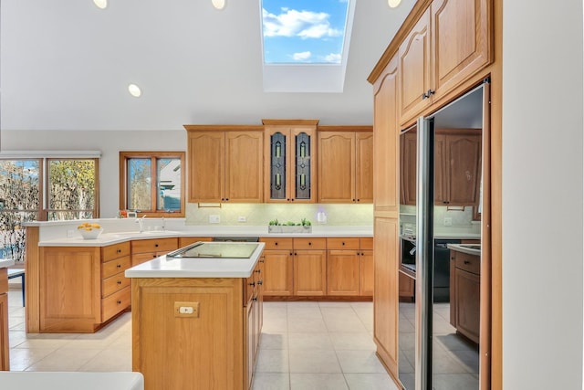 kitchen with sink, backsplash, a center island, black electric stovetop, and light tile patterned flooring