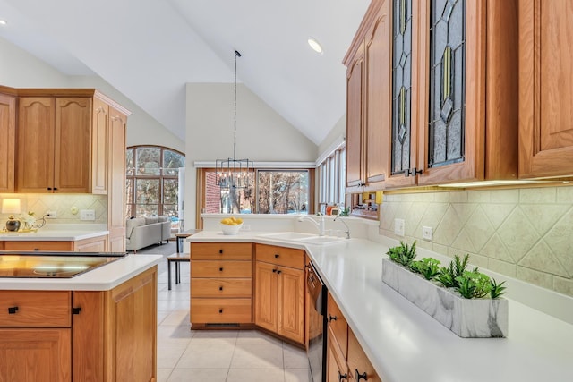 kitchen featuring lofted ceiling, sink, light tile patterned floors, backsplash, and decorative light fixtures