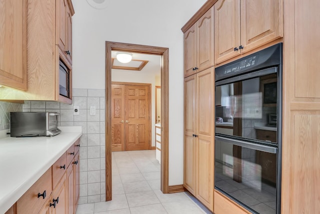 kitchen featuring light tile patterned floors, tile walls, and black appliances