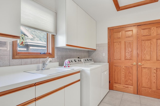 washroom featuring cabinets, separate washer and dryer, sink, and light tile patterned floors