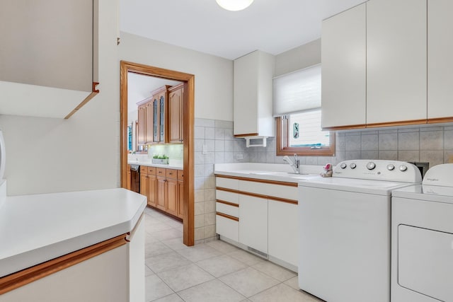 laundry room with cabinets, separate washer and dryer, sink, and light tile patterned floors