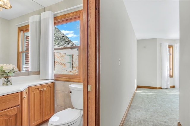 bathroom with vanity, tile walls, and toilet