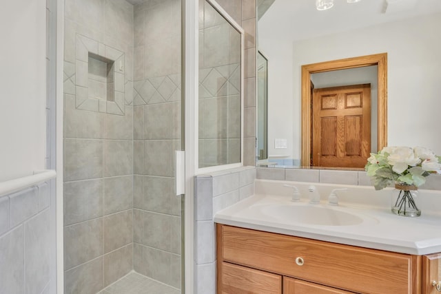 bathroom featuring a shower with door and vanity