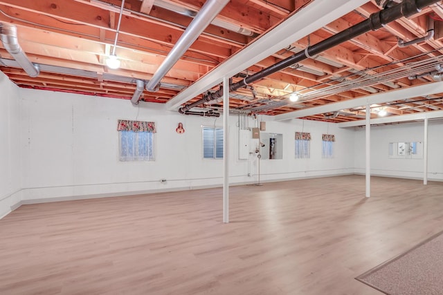 basement featuring wood-type flooring and electric panel