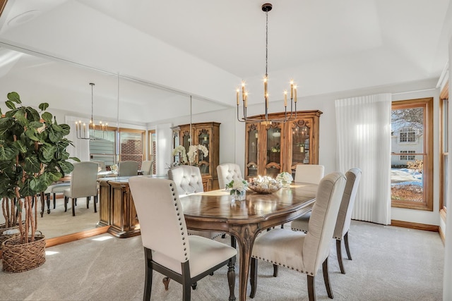 carpeted dining room with a chandelier