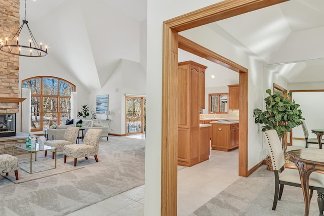 interior space featuring light carpet, a notable chandelier, and high vaulted ceiling