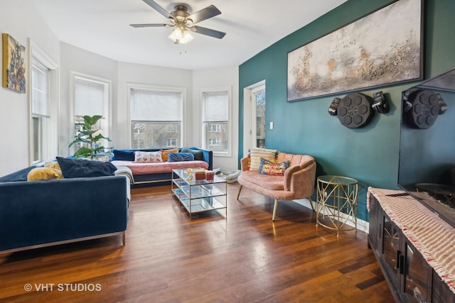 living room featuring dark wood-type flooring and ceiling fan