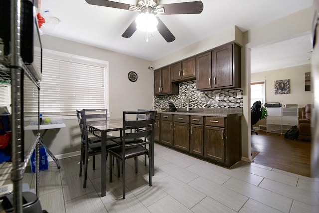 kitchen with sink, decorative backsplash, dark brown cabinets, and ceiling fan