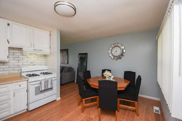 kitchen featuring white cabinetry, light hardwood / wood-style floors, and white range with gas stovetop