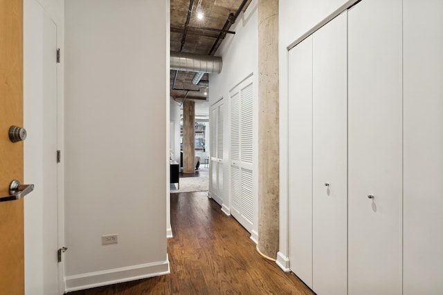 hall with a barn door and dark wood-type flooring