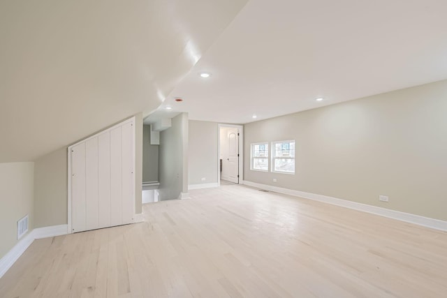 additional living space with lofted ceiling and light hardwood / wood-style flooring