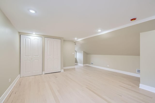 additional living space featuring lofted ceiling and light hardwood / wood-style floors