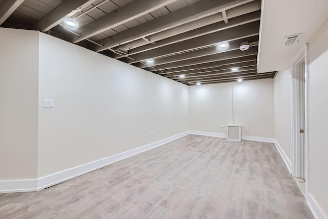 basement with light hardwood / wood-style flooring