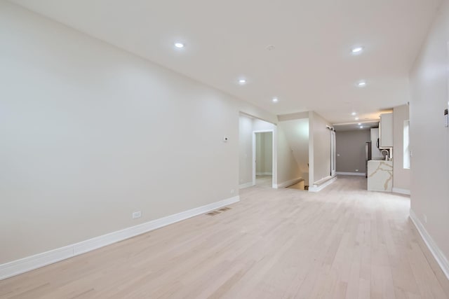 empty room featuring sink and light hardwood / wood-style floors