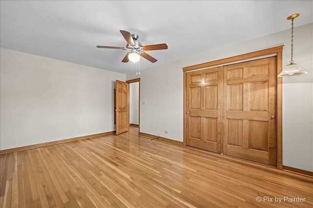 unfurnished bedroom featuring baseboards, light wood-type flooring, and ceiling fan