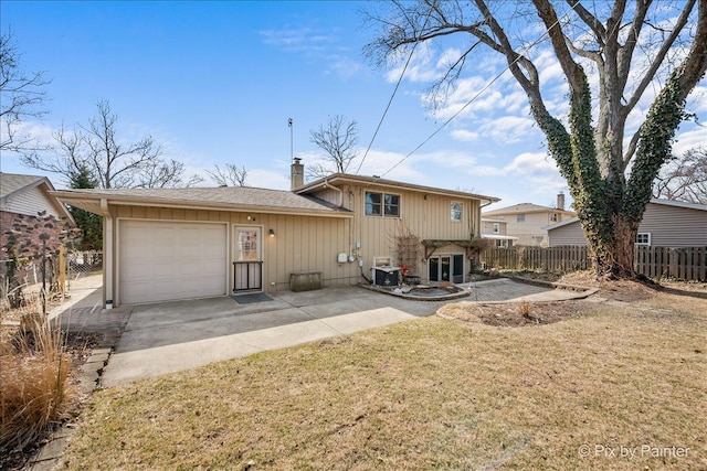 back of property featuring central air condition unit, driveway, fence, a yard, and a chimney