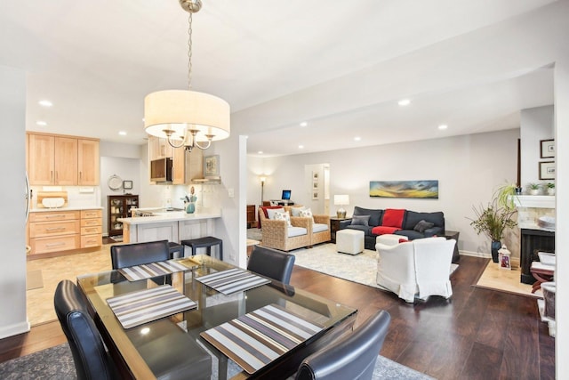 dining area with a premium fireplace, dark hardwood / wood-style flooring, and a chandelier